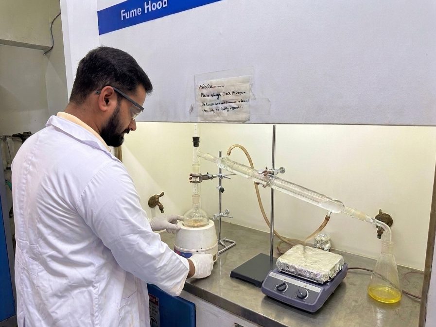 Chemist running a distillation setup inside a fume hood