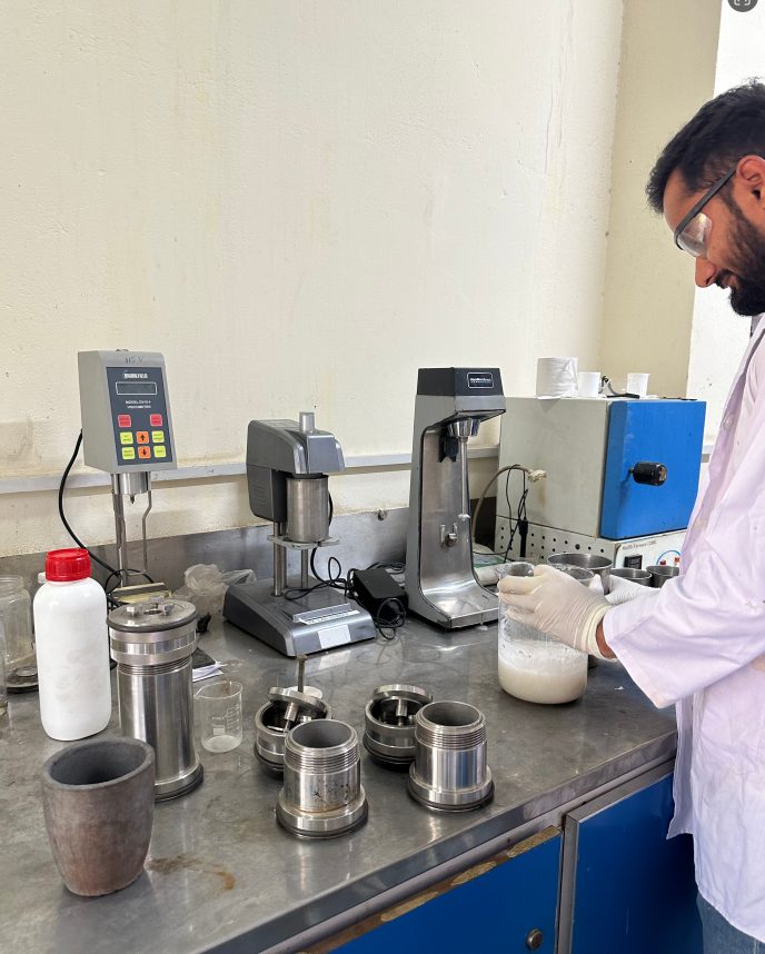 Chemist preparing drilling fluid samples with mixers and a viscometer