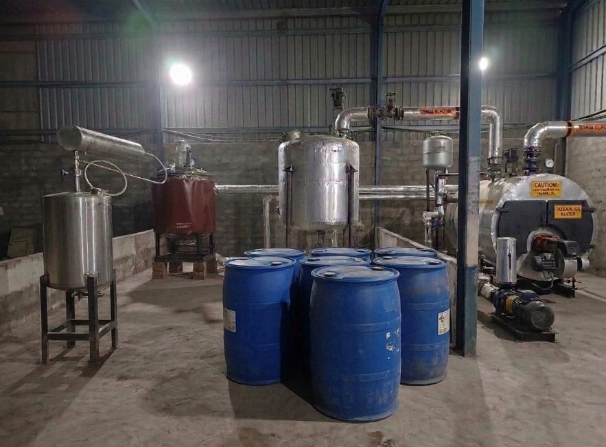 Production hall with stainless steel reactors, piping and filled drums